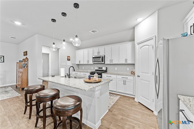 kitchen featuring light hardwood / wood-style floors, appliances with stainless steel finishes, sink, and an island with sink