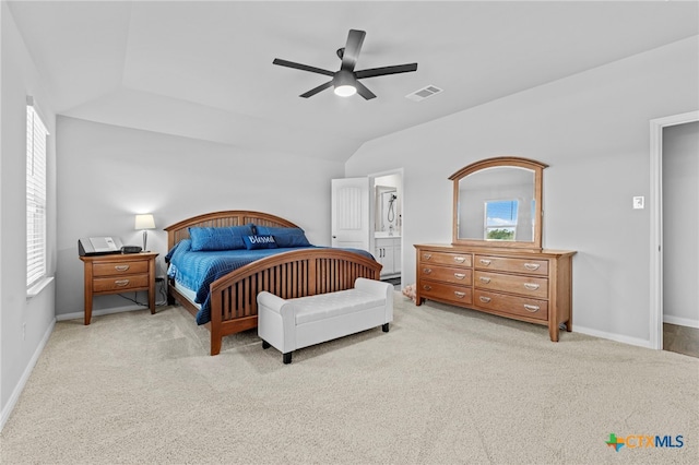 carpeted bedroom with connected bathroom, lofted ceiling, and ceiling fan