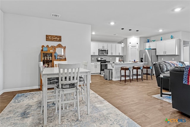 dining room with light hardwood / wood-style floors and sink