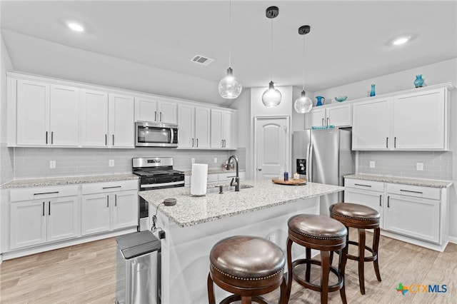 kitchen featuring white cabinetry, light wood-type flooring, and appliances with stainless steel finishes