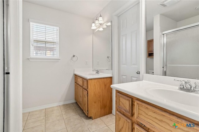 bathroom featuring tile patterned flooring, vanity, and walk in shower