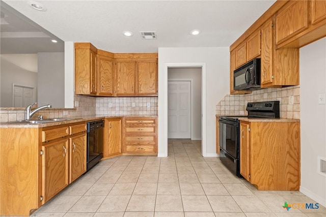 kitchen featuring tasteful backsplash, light tile patterned floors, sink, and black appliances