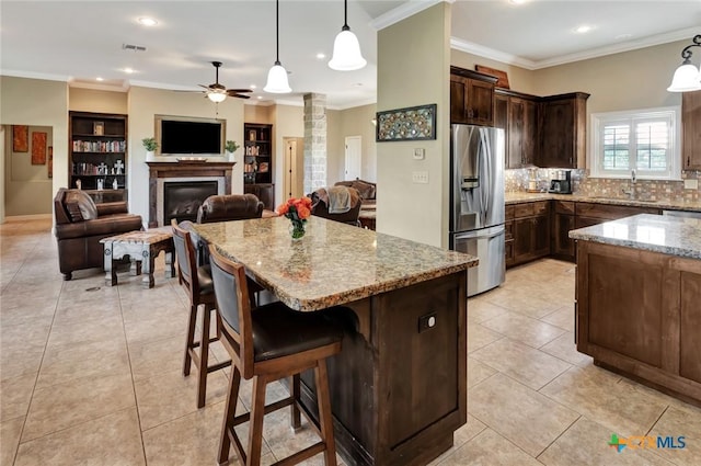 135 Wellspring Blvd, Victoria, TX 77904 - kitchen with stainless steel fridge with ice dispenser, ceiling fan, light stone countertops, ornate columns, and pendant lighting