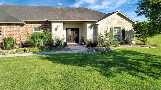 135 Wellspring Blvd, Victoria, TX 77904 - french country style house with a front yard, stone siding, and roof with shingles