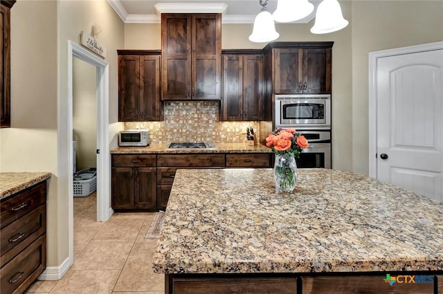 135 Wellspring Blvd, Victoria, TX 77904 - kitchen featuring stainless steel appliances, decorative backsplash, light stone countertops, crown molding, and a center island