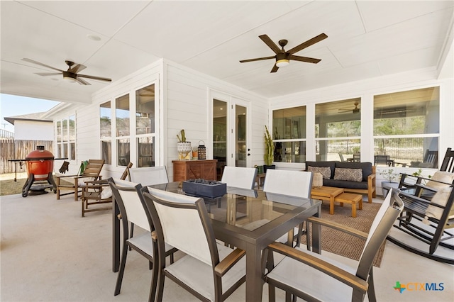 view of patio with fence, outdoor dining area, ceiling fan, french doors, and outdoor lounge area