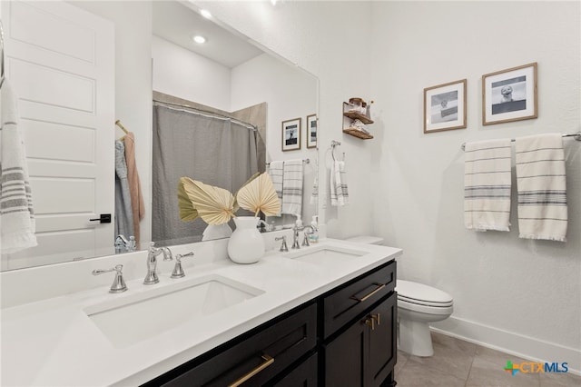 bathroom with tile patterned flooring, toilet, baseboards, and a sink