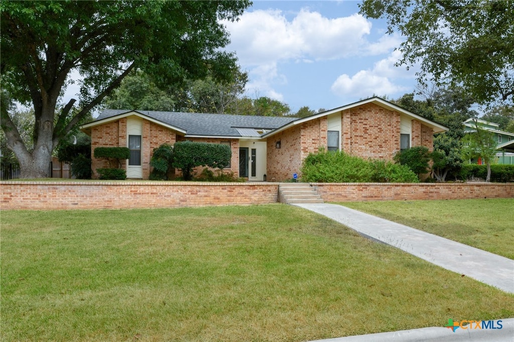 ranch-style home with a front lawn