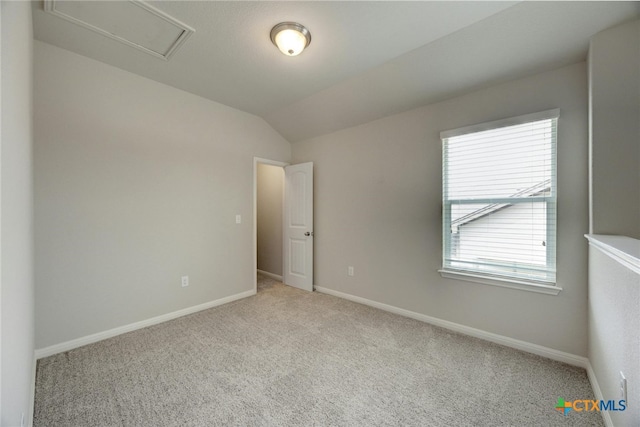 carpeted spare room featuring lofted ceiling