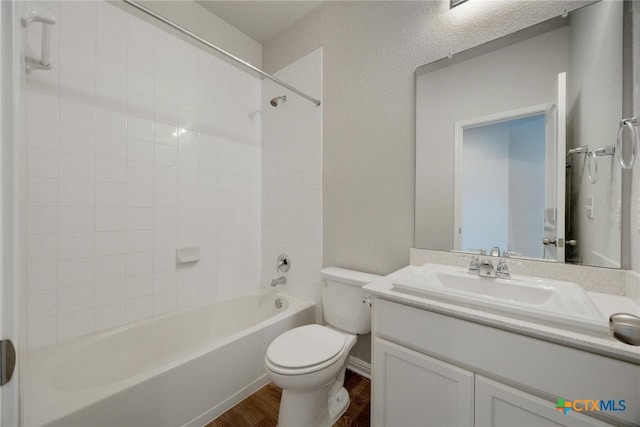 full bathroom featuring tiled shower / bath combo, vanity, hardwood / wood-style flooring, and toilet