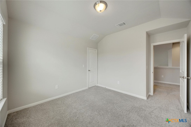 unfurnished bedroom with light colored carpet and vaulted ceiling