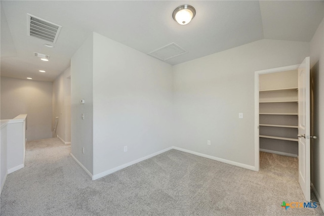 spare room with light carpet and lofted ceiling