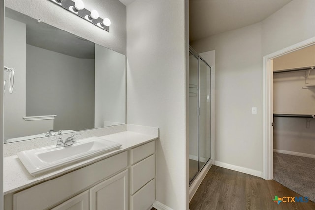 bathroom with vanity, hardwood / wood-style flooring, and a shower with shower door