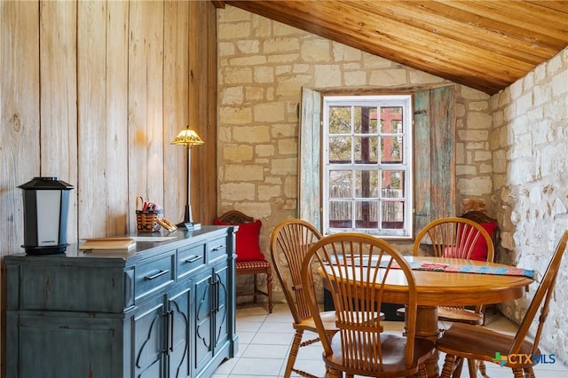 tiled dining area featuring wood walls, wood ceiling, and vaulted ceiling