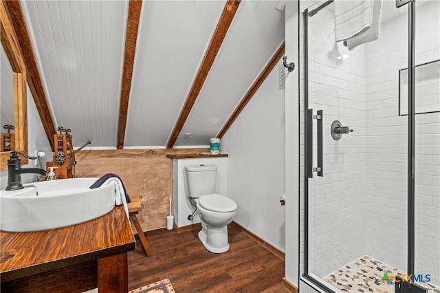 bathroom with vanity, a shower with door, lofted ceiling with beams, hardwood / wood-style flooring, and toilet