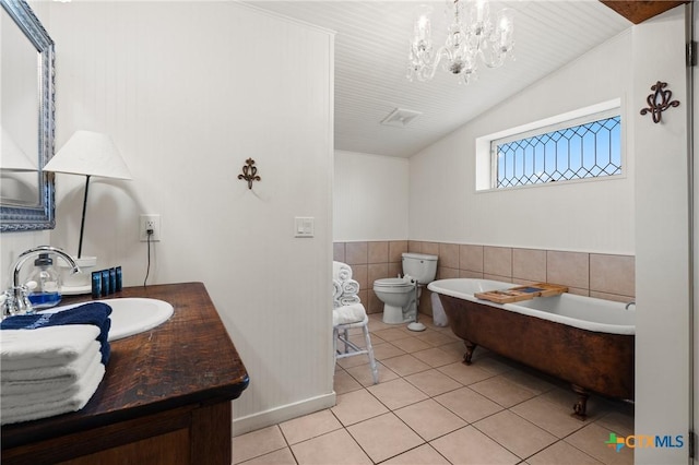 bathroom featuring tile patterned flooring, a notable chandelier, vaulted ceiling, toilet, and vanity