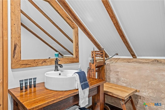 bathroom with sink and lofted ceiling with beams