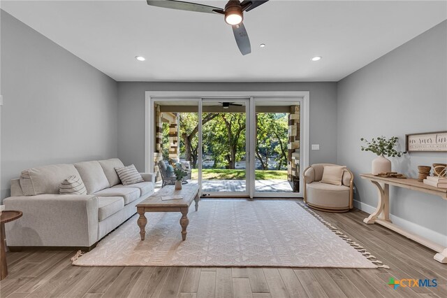 living room featuring ceiling fan and wood-type flooring