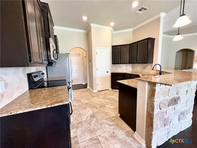 416 Coventry Dr, Temple, TX 76502 - kitchen featuring arched walkways, light stone countertops, crown molding, a peninsula, and dark brown cabinetry