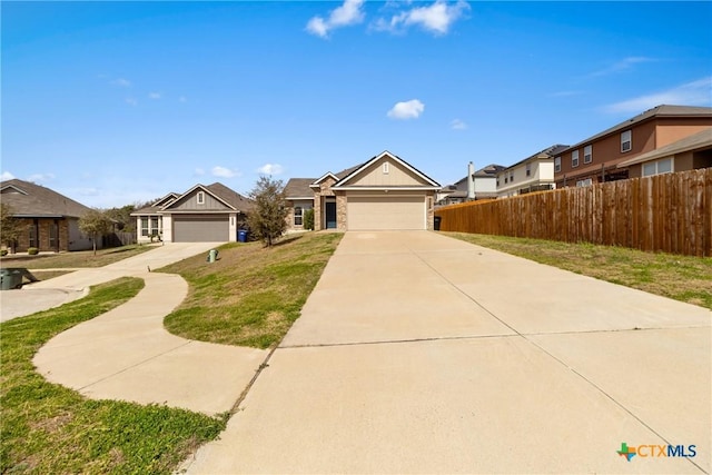 view of front facade featuring a garage, fence, concrete driveway, and a front yard