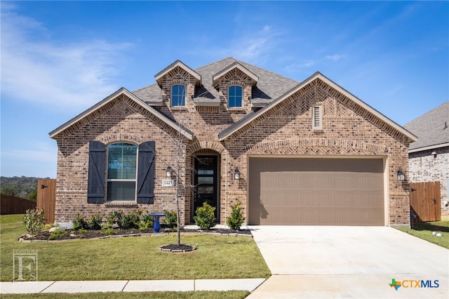 french country style house featuring concrete driveway, brick siding, fence, and a front lawn