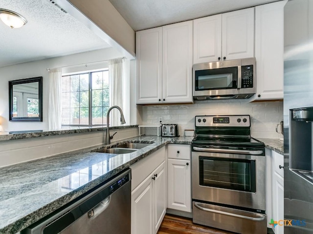 1133 Ashby St, Seguin, TX 78155 - kitchen featuring stainless steel appliances, a sink, white cabinetry, and a textured ceiling
