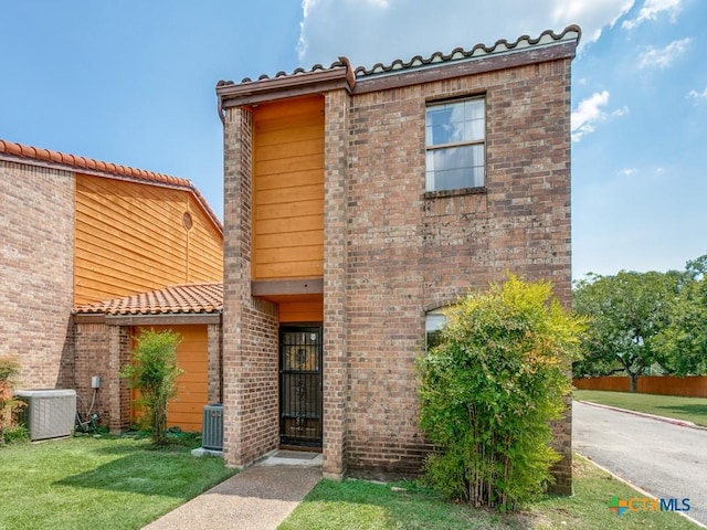 1133 Ashby St, Seguin, TX 78155 - view of front of home featuring central AC, a tile roof, and brick siding