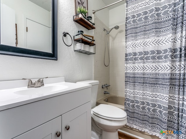 full bathroom featuring shower / bath combo, vanity, toilet, and a textured ceiling