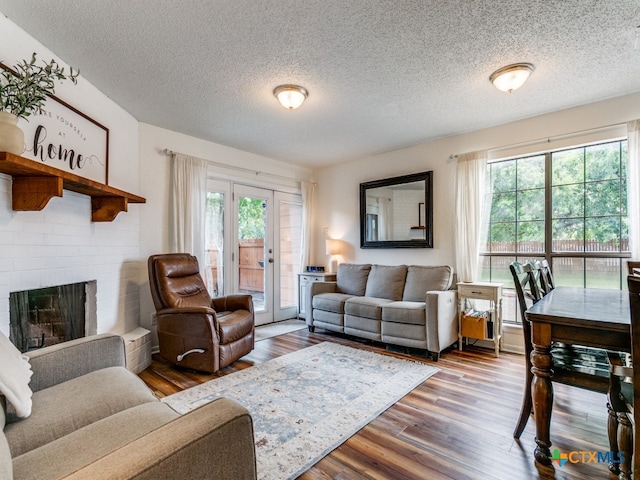 living room featuring hardwood / wood-style floors, a fireplace, and a textured ceiling