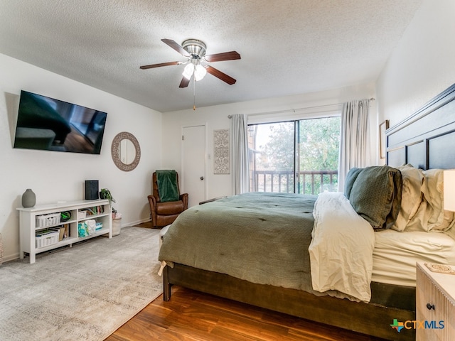 bedroom featuring hardwood / wood-style floors, access to exterior, ceiling fan, and a textured ceiling