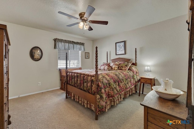 bedroom featuring light colored carpet, baseboards, and a ceiling fan