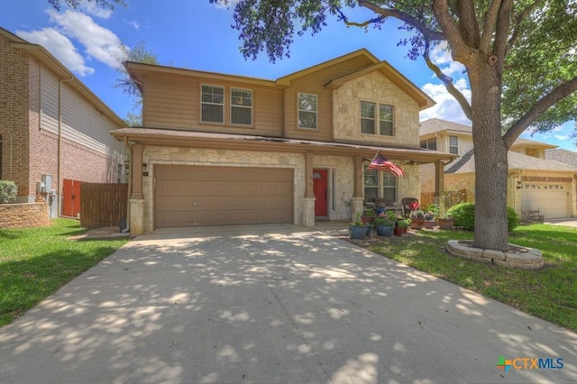 traditional home with stone siding, driveway, a garage, and covered porch