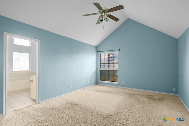 unfurnished bedroom featuring ceiling fan, vaulted ceiling, light carpet, and ensuite bath