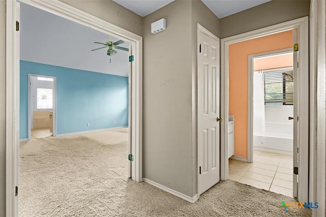 corridor featuring plenty of natural light and light colored carpet