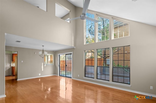 unfurnished living room featuring high vaulted ceiling and an inviting chandelier