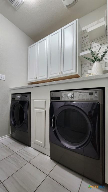9012 Lonesome Oak Dr, Temple, TX 76502 - laundry room featuring washer / dryer, cabinet space, and light tile patterned floors