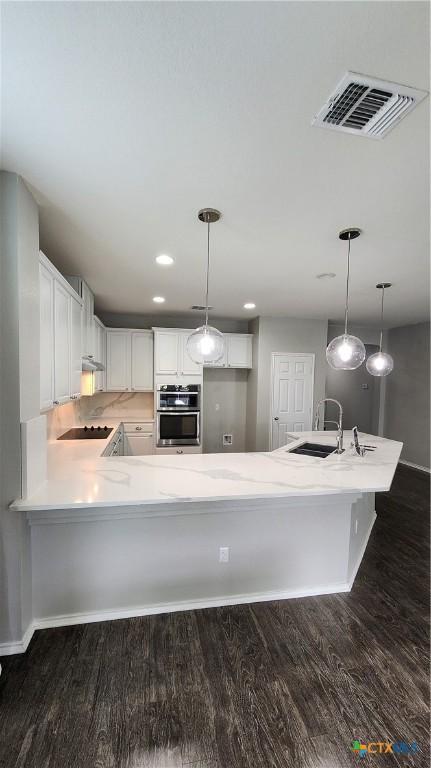 9012 Lonesome Oak Dr, Temple, TX 76502 - kitchen featuring a sink, oven, light countertops, dark wood-style floors, and white cabinetry