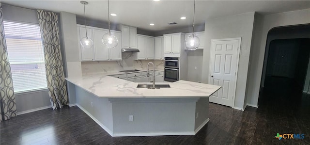 9012 Lonesome Oak Dr, Temple, TX 76502 - kitchen featuring a sink, a peninsula, dark wood-style flooring, double oven, and baseboards