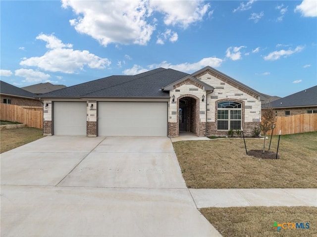 view of front of home with a garage and a front lawn