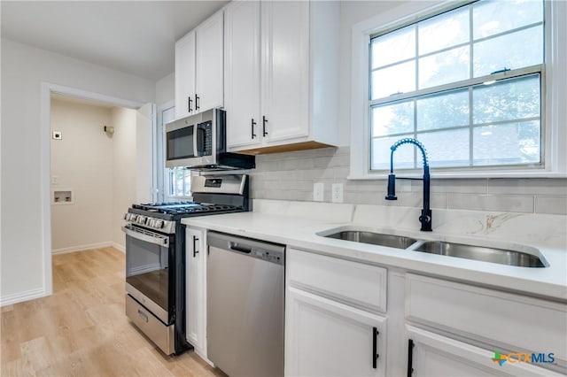 3524 Swan St, Fort Worth, TX 76117 - kitchen with stainless steel appliances, plenty of natural light, white cabinets, and light wood finished floors