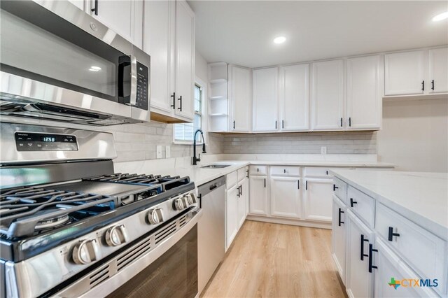 3524 Swan St, Fort Worth, TX 76117 - kitchen with stainless steel appliances, light wood-style flooring, white cabinetry, decorative backsplash, and recessed lighting