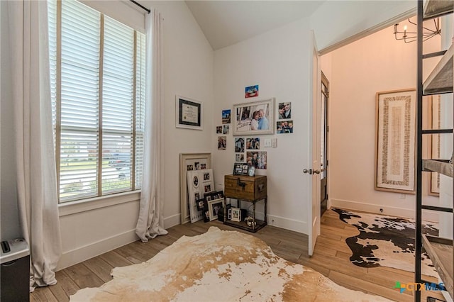 interior space with hardwood / wood-style flooring and vaulted ceiling