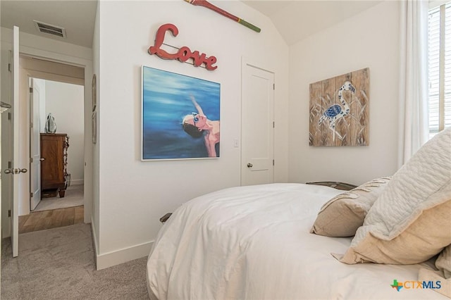 carpeted bedroom with vaulted ceiling and multiple windows