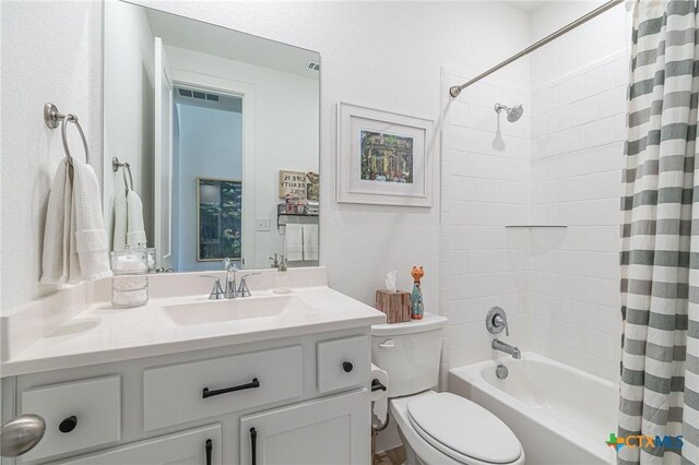 full bathroom with vanity, shower / tub combo, and toilet