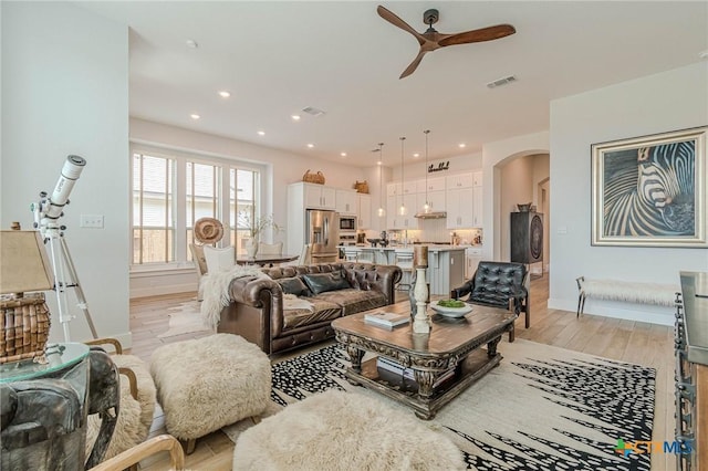 living room featuring ceiling fan and light wood-type flooring