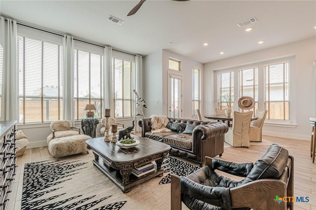 living room featuring ceiling fan and light hardwood / wood-style flooring