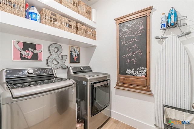 laundry area with hardwood / wood-style floors and washing machine and clothes dryer