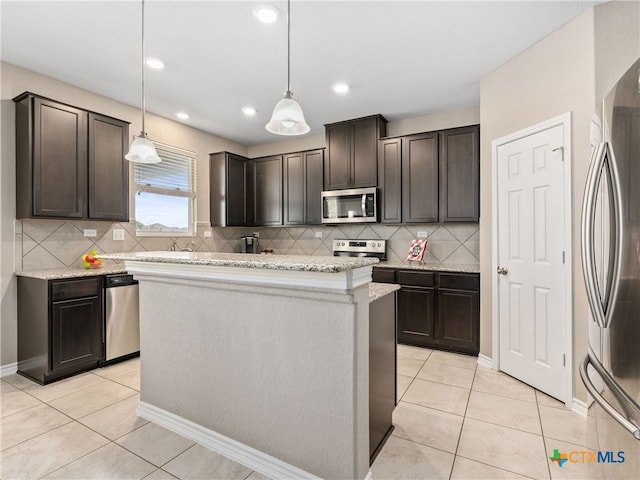 kitchen featuring appliances with stainless steel finishes, a center island, pendant lighting, and dark brown cabinets