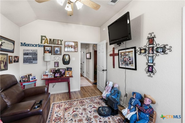 living room with wood-type flooring, vaulted ceiling, and ceiling fan