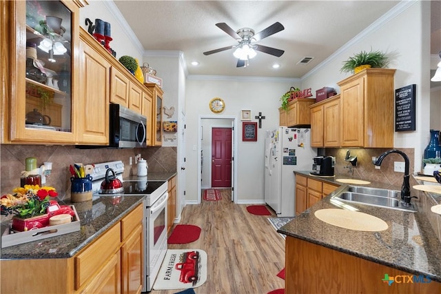 kitchen with backsplash, white appliances, crown molding, sink, and light hardwood / wood-style floors